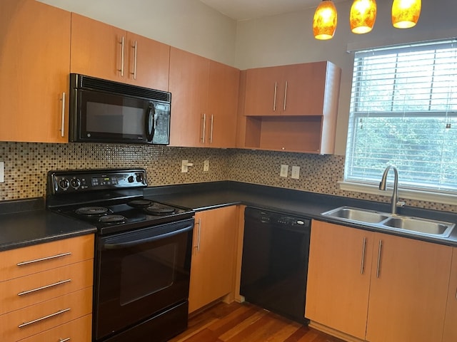 kitchen with dark countertops, a sink, backsplash, and black appliances