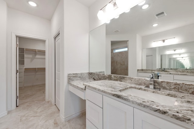 bathroom with tile patterned flooring, walk in shower, and vanity