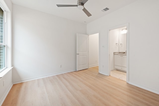 unfurnished bedroom featuring ceiling fan, ensuite bathroom, and light hardwood / wood-style flooring