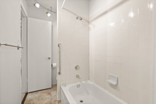 bathroom with tiled shower / bath combo and tile patterned floors