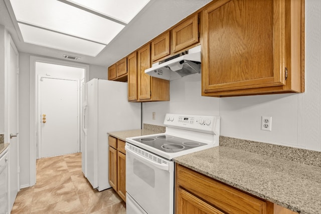 kitchen featuring light stone counters, light tile patterned flooring, and white electric stove