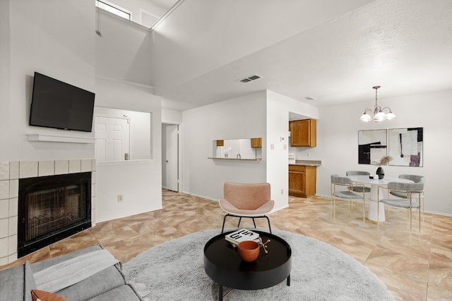 living room featuring light tile patterned floors, a fireplace, and a chandelier