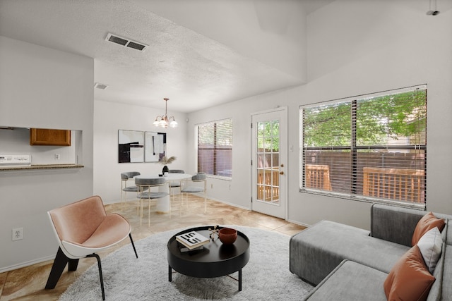 tiled living room with a textured ceiling and a notable chandelier