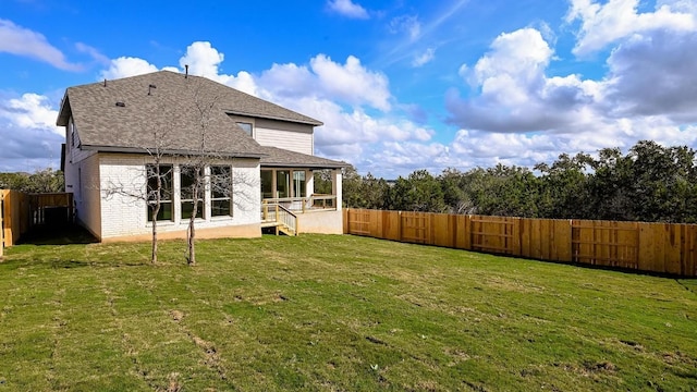 rear view of house featuring a yard