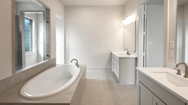 bathroom featuring vanity, tile patterned floors, and tiled tub