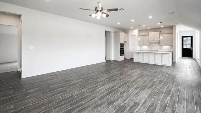 unfurnished living room with ceiling fan and sink