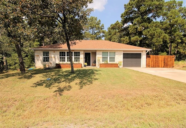 single story home featuring driveway, a garage, stone siding, fence, and a front lawn