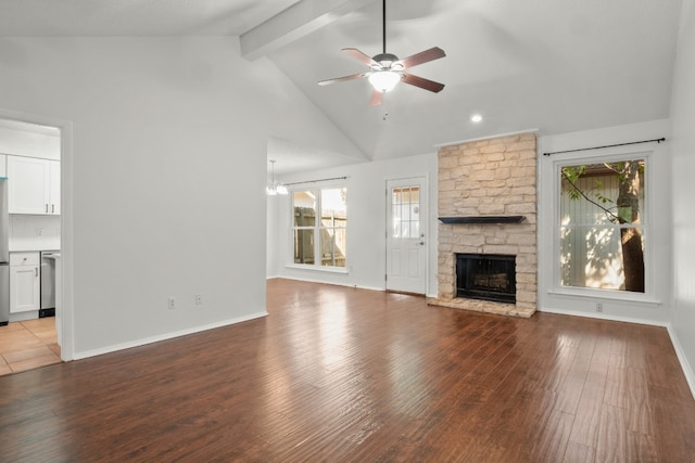 unfurnished living room with a wealth of natural light, hardwood / wood-style floors, beam ceiling, and a fireplace