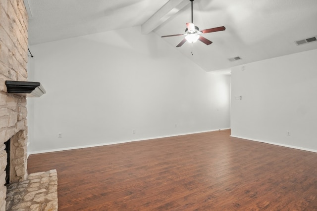 unfurnished living room with beamed ceiling, wood-type flooring, ceiling fan, and a stone fireplace