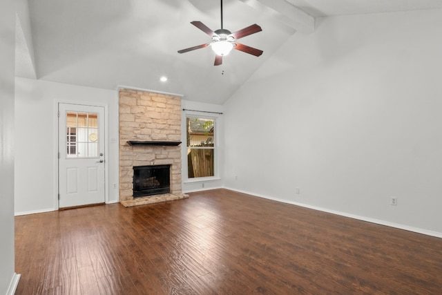 unfurnished living room featuring lofted ceiling with beams, ceiling fan, dark wood-type flooring, and a stone fireplace