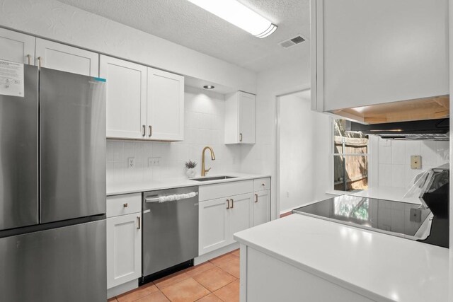 kitchen featuring backsplash, sink, appliances with stainless steel finishes, and white cabinetry