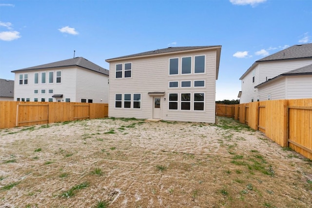 rear view of house featuring a fenced backyard