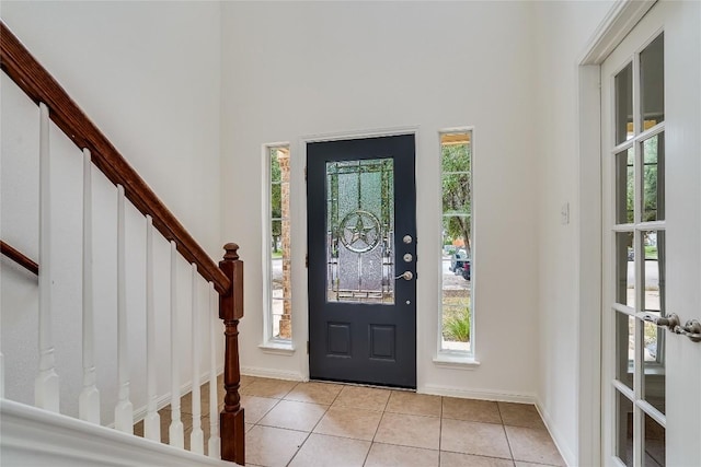 360 Wildhorse Crk, Buda, TX 78610 - entryway featuring light tile patterned floors, stairs, a high ceiling, and baseboards