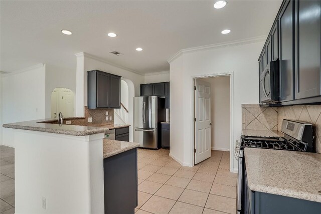 kitchen with appliances with stainless steel finishes, crown molding, and decorative backsplash