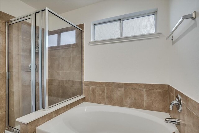 bathroom featuring plus walk in shower and a wealth of natural light