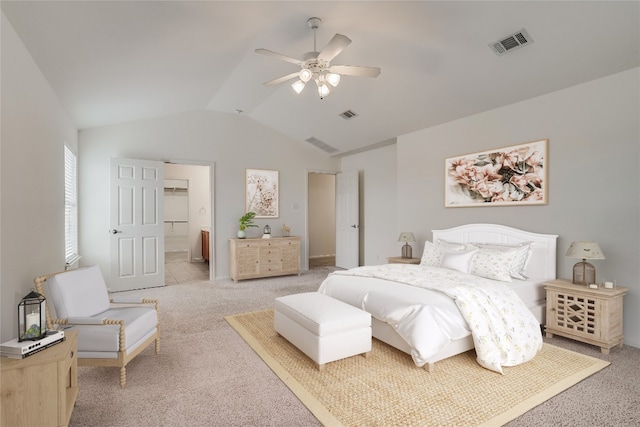 carpeted bedroom with lofted ceiling, ceiling fan, and ensuite bath