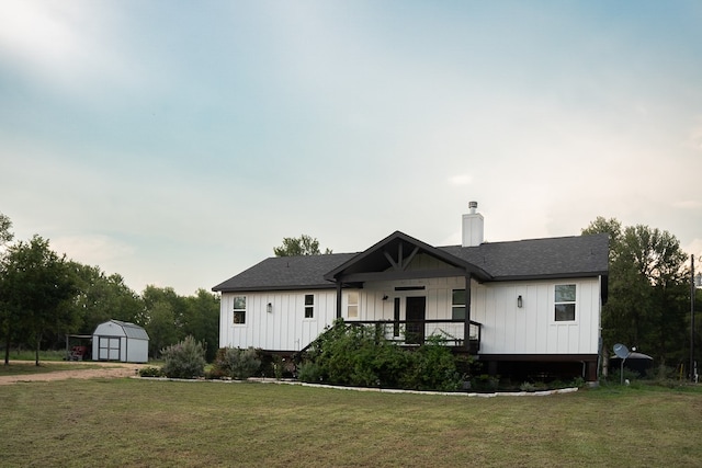 view of front of home featuring a storage unit and a front lawn