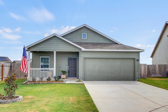 view of front of home featuring a garage, a front lawn, and covered porch