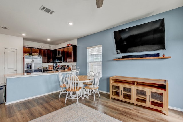 interior space featuring sink, appliances with stainless steel finishes, dark brown cabinets, and light hardwood / wood-style floors