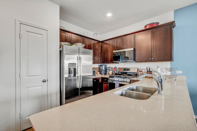 kitchen with appliances with stainless steel finishes, dark brown cabinets, and sink