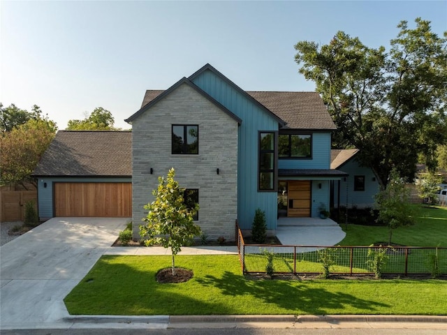 contemporary house with a garage, concrete driveway, stone siding, fence, and board and batten siding