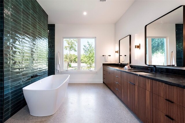 bathroom with a bath, tile walls, and vanity