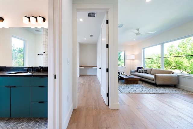 interior space with a wealth of natural light, sink, and light hardwood / wood-style floors