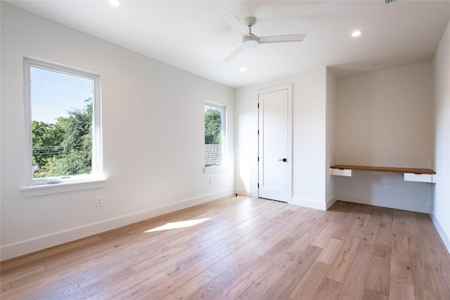 unfurnished bedroom with recessed lighting, baseboards, light wood finished floors, and built in study area