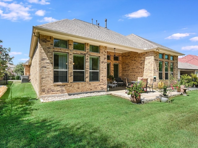 back of house with a yard and a patio