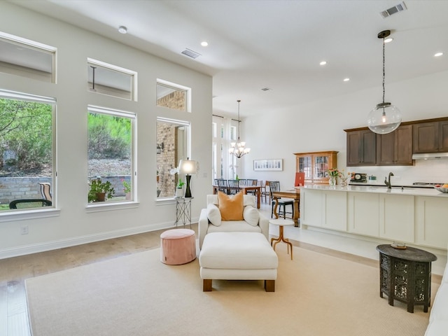 sitting room with sink, an inviting chandelier, and light wood-type flooring