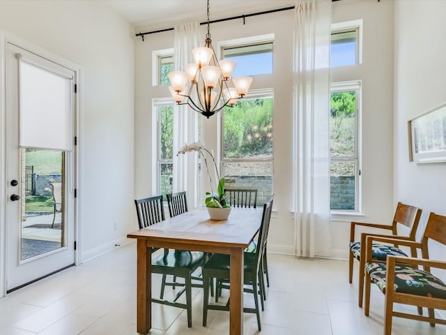 dining space with light tile patterned floors, plenty of natural light, and a notable chandelier