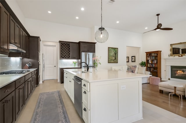 kitchen with backsplash, white cabinets, sink, appliances with stainless steel finishes, and decorative light fixtures