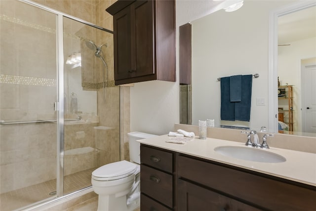 bathroom featuring vanity, toilet, and a shower with door