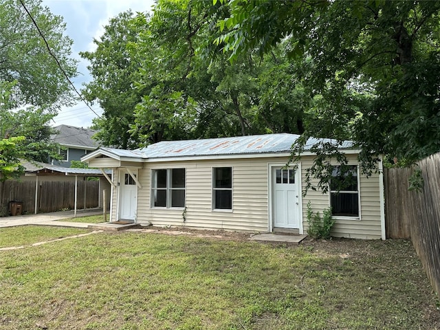 rear view of property featuring a lawn