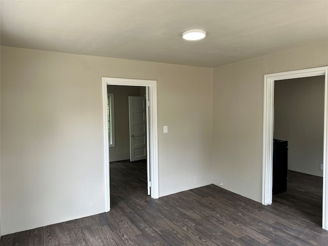 spare room with dark wood-type flooring