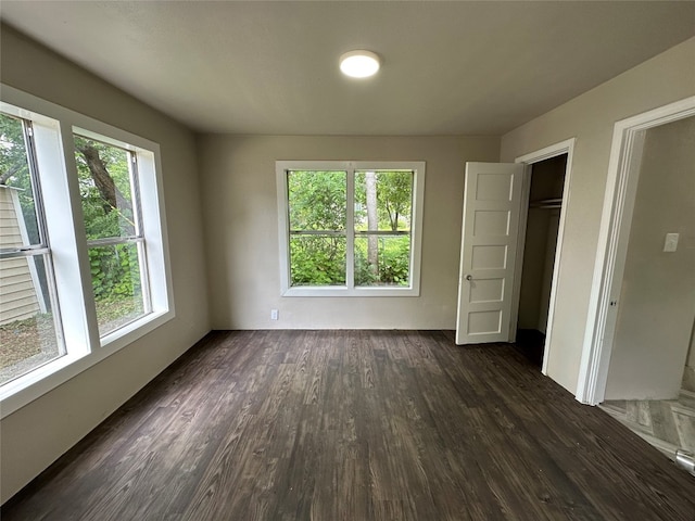 unfurnished bedroom featuring a closet and dark hardwood / wood-style flooring