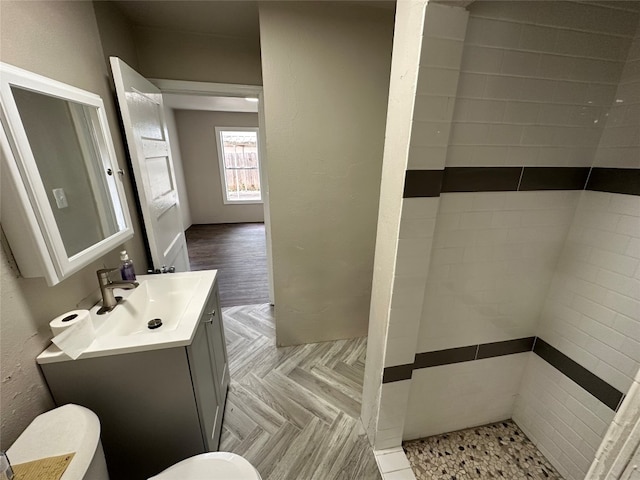 bathroom with vanity, toilet, and parquet flooring