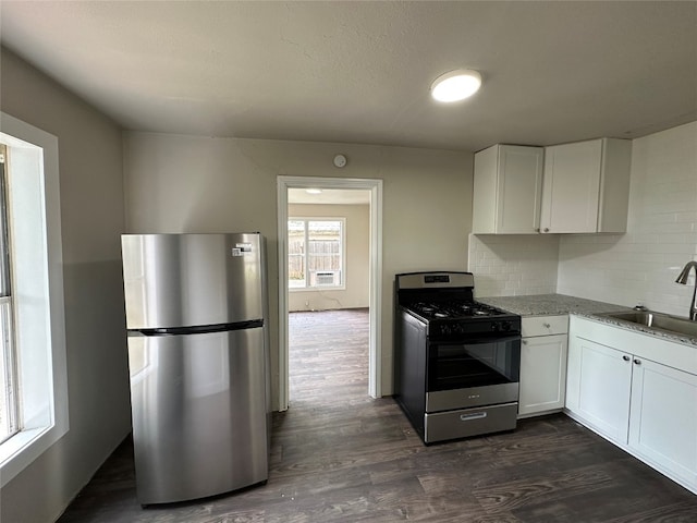 kitchen featuring stainless steel appliances, white cabinetry, sink, and dark hardwood / wood-style flooring