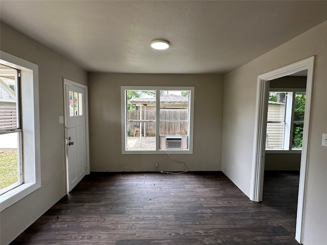 interior space with a textured ceiling, plenty of natural light, and dark hardwood / wood-style flooring