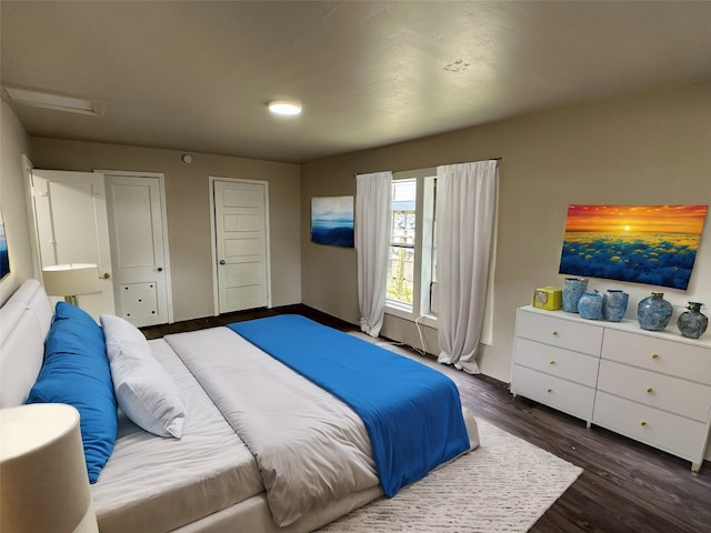 bedroom with dark hardwood / wood-style floors