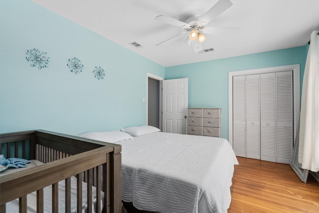 bedroom featuring ceiling fan, a closet, and light wood-type flooring