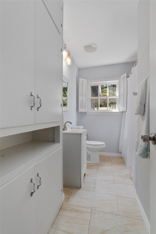 bathroom featuring tile patterned floors, a shower with curtain, toilet, and vanity