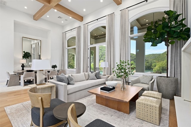 living area featuring beamed ceiling, recessed lighting, visible vents, and wood finished floors