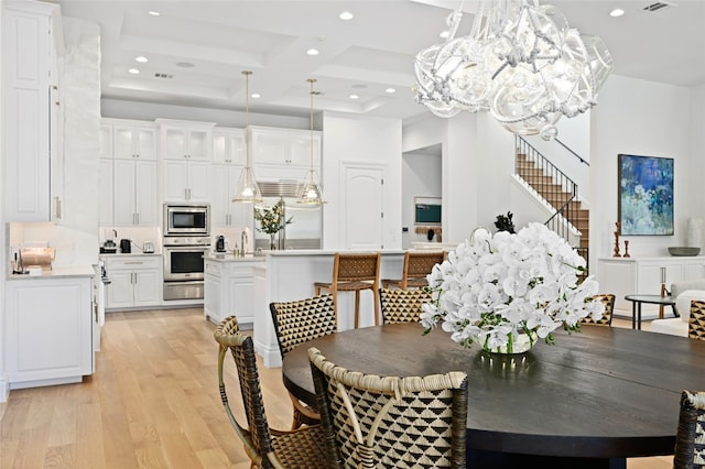 dining room with sink, coffered ceiling, beamed ceiling, a chandelier, and light hardwood / wood-style floors