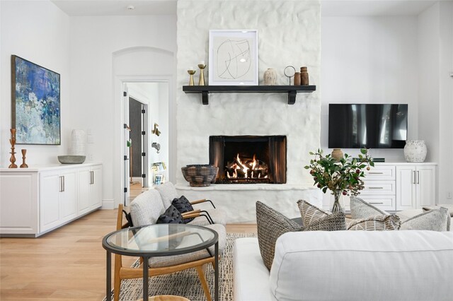 living room with light wood finished floors and a high end fireplace