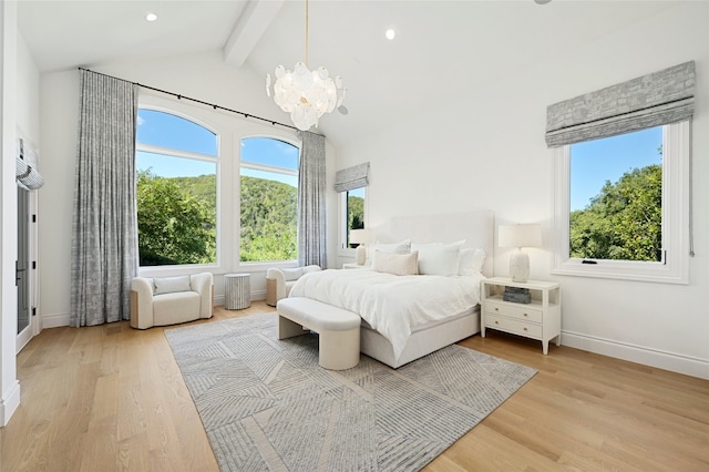 bedroom with light wood-type flooring, lofted ceiling with beams, and a chandelier