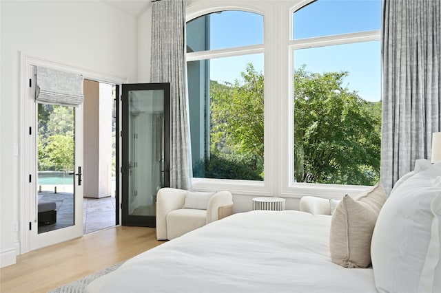 bedroom with access to exterior, light hardwood / wood-style flooring, and french doors