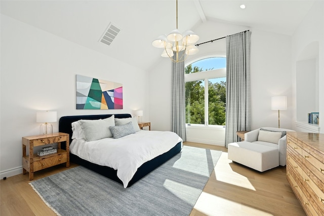 bedroom featuring an inviting chandelier, light hardwood / wood-style flooring, and vaulted ceiling