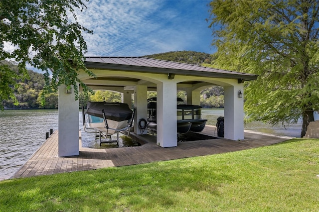 dock area featuring boat lift, a lawn, and a water view