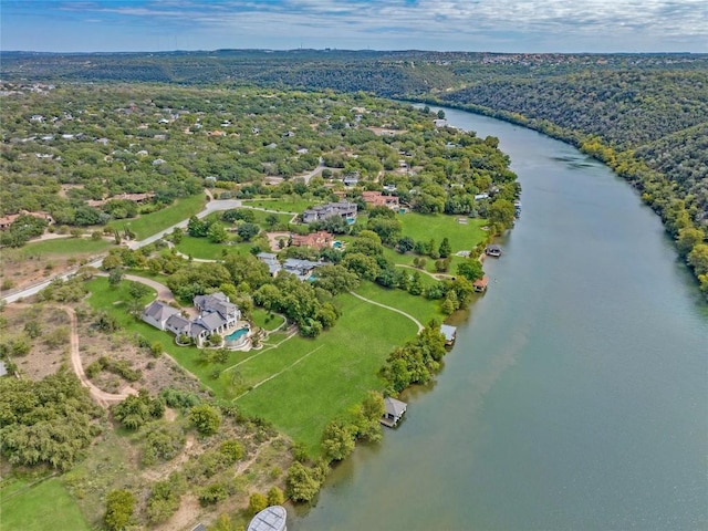 birds eye view of property with a water view and a wooded view